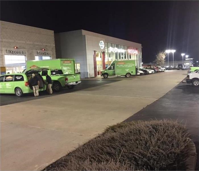 SERVPRO vehicles parked in front of a building to start working on a disaster emergency