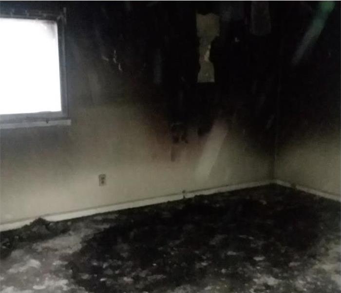 empty room burned, walls damaged by fire