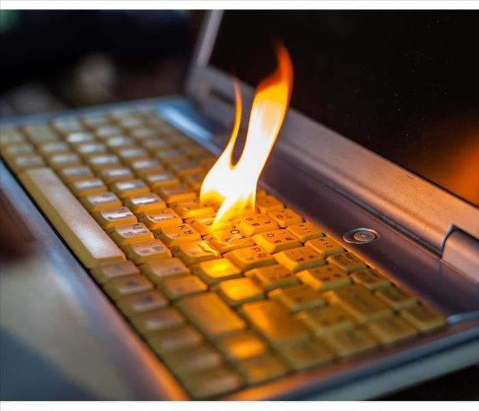 Flame coming out a computer keyboard. Concept of electronics damaged by fire.